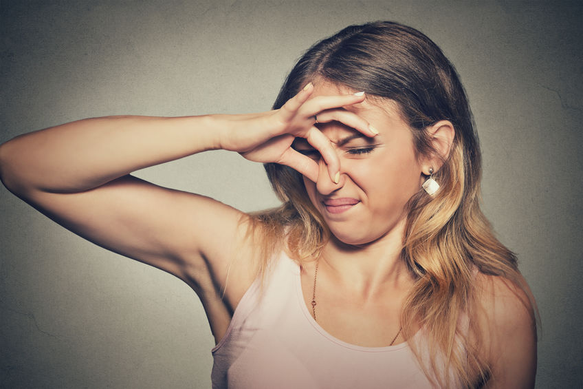 woman pinches nose with fingers looks with disgust something stinks bad smell